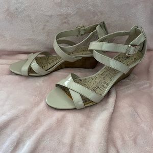 Beige sandal w/small wedge heel. Small scuff on the back of the right shoe.